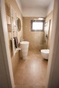 a bathroom with a sink and a tub and a toilet at CONSTA Luxury Apartments in Paralio Astros
