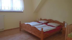 a bedroom with a bed with four pillows on it at Ferienreihenhäuser Roswitha in Frauenberg