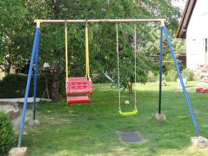 a playground with two swings in a yard at Ferienreihenhäuser Roswitha in Frauenberg