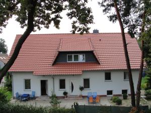 a house with a red roof and blue chairs at Ferienreihenhäuser Roswitha in Frauenberg