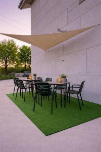 a group of tables and chairs on a green rug at Isa Rooms Sarria in Sarria +7 photos