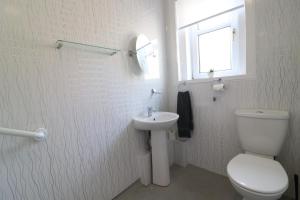 a white bathroom with a toilet and a sink at Signature - Bueno View - Greenock in Greenock +17 photos