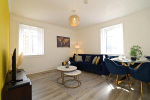 a living room with a blue couch and a table at Signature - Bueno View - Greenock in Greenock