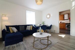 a living room with a blue couch and a table at Signature - Bueno View - Greenock in Greenock