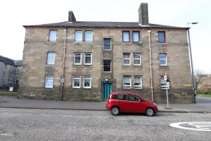 a red car parked in front of a brick building at Signature - Bueno View - Greenock in Greenock