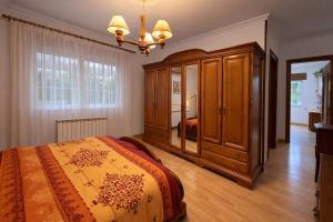 a bedroom with a bed and a large wooden cabinet at Isa Rooms Sarria in Sarria