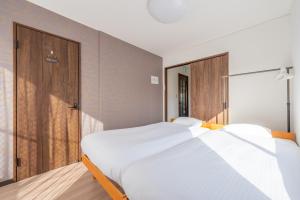 a bedroom with two beds and a sliding glass door at 狐狐 Coco in Kyōto +37 photos