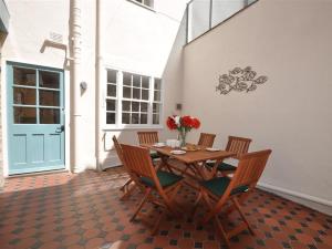 a wooden table with chairs and a vase of flowers at Safe Harbour in Weymouth