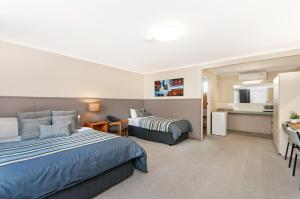 a hotel room with two beds and a kitchen at Melaleuca Motel in Portland