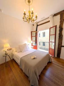 a bedroom with a large bed and a chandelier at Basque Suite in Bilbao