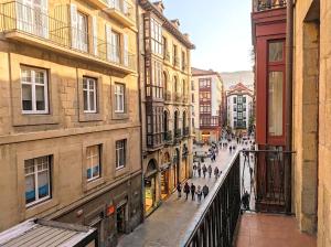 a group of people walking down a city street at Basque Suite in Bilbao