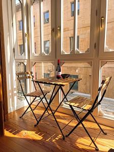 a table and two chairs in a room with windows at Basque Suite in Bilbao