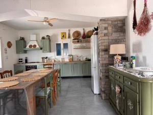 a kitchen with green cabinets and a table with chairs at Villa Roma Holidays in Jesolo