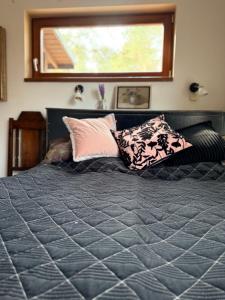 a bedroom with a bed with pillows and a window at Art space Bundulis in Saulkrasti