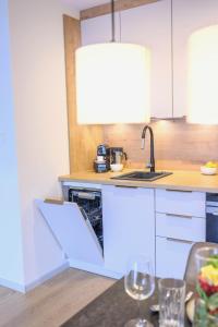 a kitchen with white cabinets and a sink at Miamare Dziwnow - Komfort Apartment, Panorama, Beach, Pool & Wellness in Dziwnów
