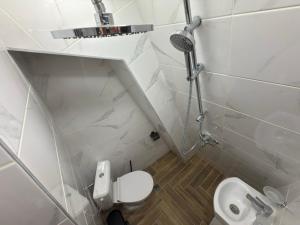 a small white bathroom with a toilet and a shower at Stayhome in Ruse
