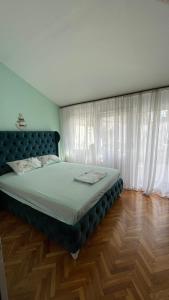a bedroom with a large bed with white curtains at Golden Grape House in Budva