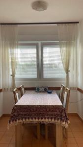 a dining room with a table and two windows at Golden Grape House in Budva