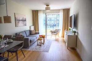 a living room with a couch and a table at Miamare Dziwnow - Komfort Apartment, Panorama, Beach, Pool & Wellness in Dziwnów