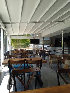 a cafeteria with wooden tables and chairs and a tv at Midis Park Otel in Şarköy