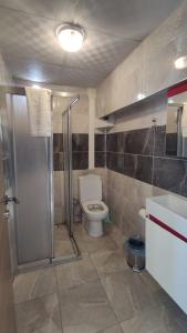 a bathroom with a toilet and a shower and a sink at Midis Park Otel in Şarköy
