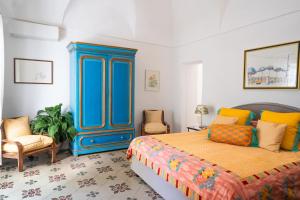 a bedroom with a bed and a blue cabinet at Casa Sam Positano in Positano