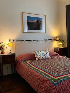 a bedroom with a large bed with a colorful blanket at La Casetta - Home Gallery in San Fiorano