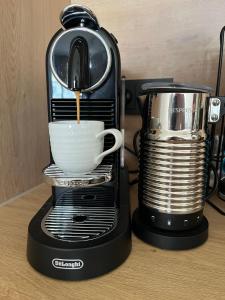 a coffee maker is making a cup of coffee at Miamare Dziwnow - Komfort Apartment, Panorama, Beach, Pool & Wellness in Dziwnów +49 photos