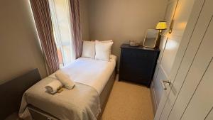 a small bedroom with a bed and a window at Number 6 Clevedon in Walton Down +3 photos