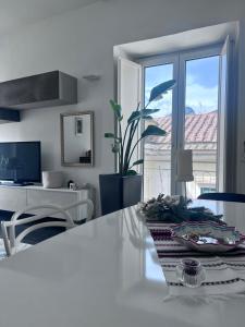 a white kitchen with a table and a dining room at Maison Grimoaldo10 in Salerno