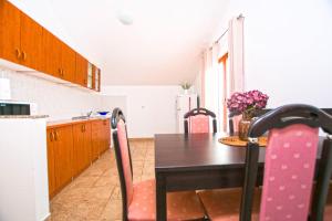 a kitchen with a table and chairs in a kitchen at Apartment Tina in Obrovac +9 photos