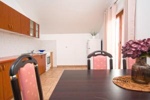 a kitchen with a table and two chairs and a refrigerator at Apartment Tina in Obrovac