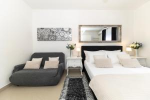 a bedroom with a bed and a couch and a mirror at Central Square Luxury Boutique in Zadar