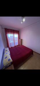 a bedroom with a large bed with a red window at Casa Enrique in Alicante