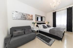 a bedroom with a bed and a couch and a chandelier at Central Square Luxury Boutique in Zadar +36 photos