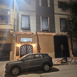 a black car parked in front of a building at Beau F3 in Dar el Beïda