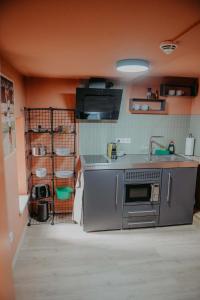 a kitchen with a stove and a sink and a shelf at sleepArt match point in Celle