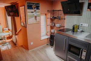 a kitchen with orange walls and a counter top at sleepArt match point in Celle