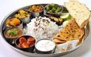a plate of food with rice and different types of food at Hotel Amber Railway station in Vadodara