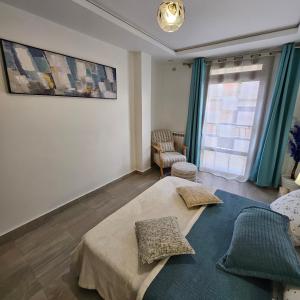 a bedroom with a bed and a chair and a window at Beau F3 in Dar el Beïda