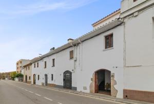 a row of white buildings on a street at Casa con patio, piedra y luz natural in Sant Pere de Ribes
