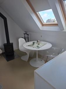 a white table and chair in a room with a window at Studio Les 4 Vents in Tréffiagat