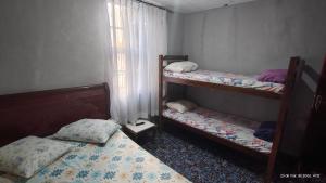 two bunk beds in a room with a window at Pousada Itararé in São Vicente