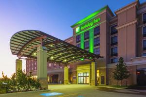 a hospital building with a green sign on it at Holiday Inn Hotel & Suites Red Deer by IHG in Red Deer