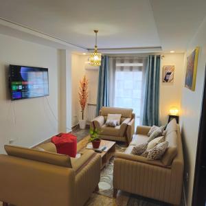 a living room with two couches and a tv at Beau F3 in Dar el Beïda