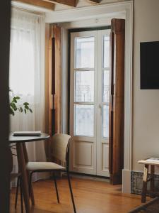 a room with a door and a table and chairs at Casa Solayme Vitória in Lisbon
