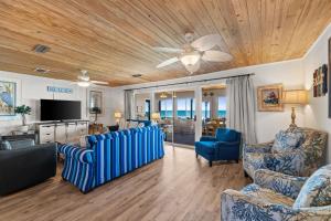a living room with blue chairs and a flat screen tv at Sunny Beach by Book That Condo in Panama City Beach