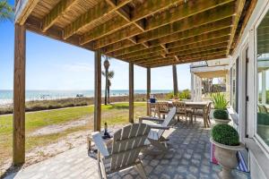 a patio with a table and chairs and the beach at Sunny Beach by Book That Condo in Panama City Beach