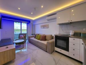 a kitchen and living room with a couch and a table at IFESTOS SUITES by SDR in Paralia Katerinis