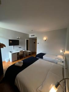 a hotel room with two beds and a television at Master Hotel in Cadelbosco di Sopra